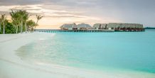 playa y villas al atardecer en Heritance Aarah Maldives